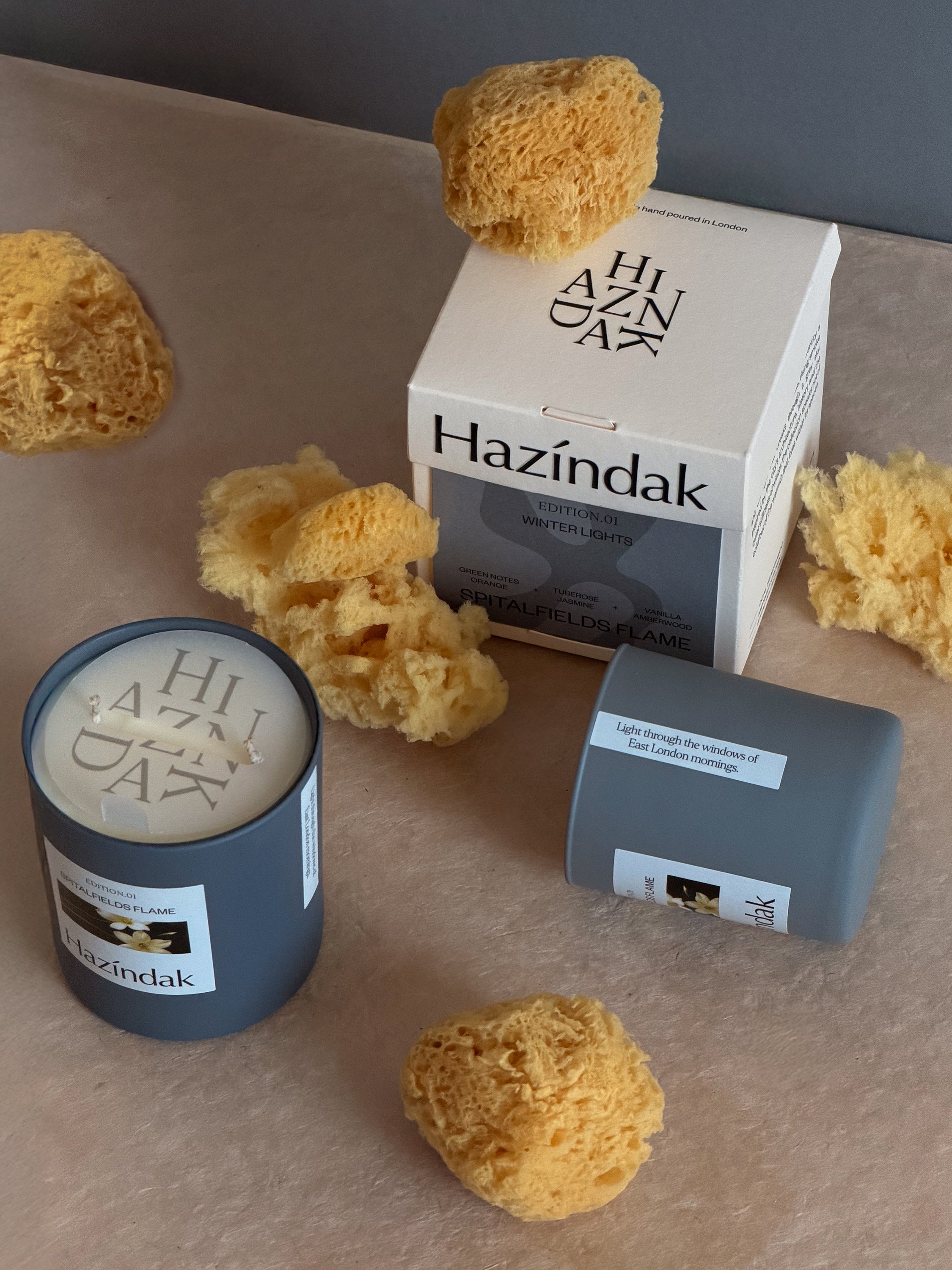 A glowing Hazindak candle styled in a modern London home interior, creating a warm ambiance.