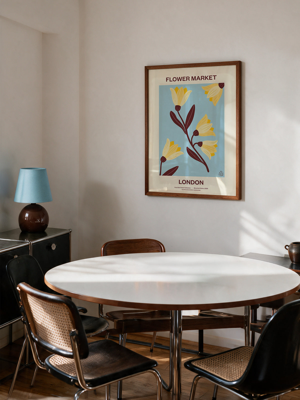 Flower Market London No.01 Sky botanical wall art styled above a dining table in a modern interior